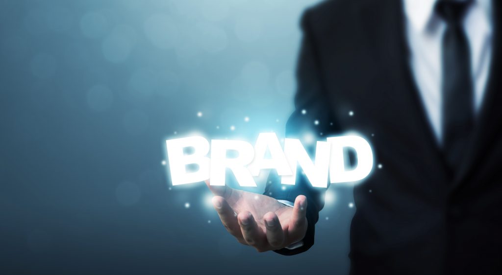 un homme porte dans sa main le texte "Brand"