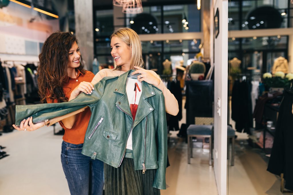 Une vendeuse aide une femme à choisir un blouson avec proximité