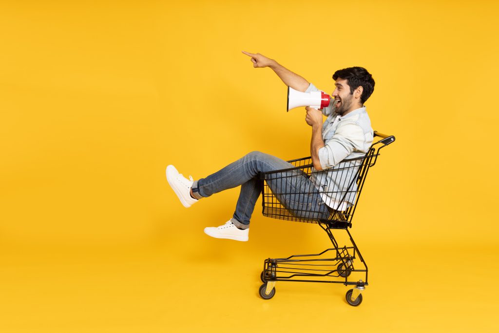 Homme dans un caddy qui parle dans un haut-parleur pour sa communication de proximité